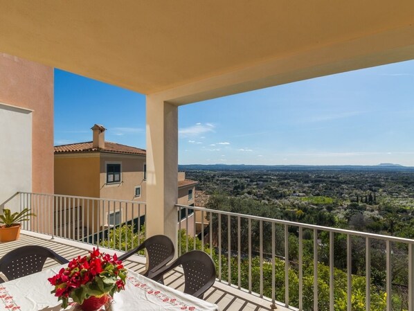 A balcony with a table, chairs, and a potted plant. - Biali - Beautiful house with stunning views in Búger (Búger)