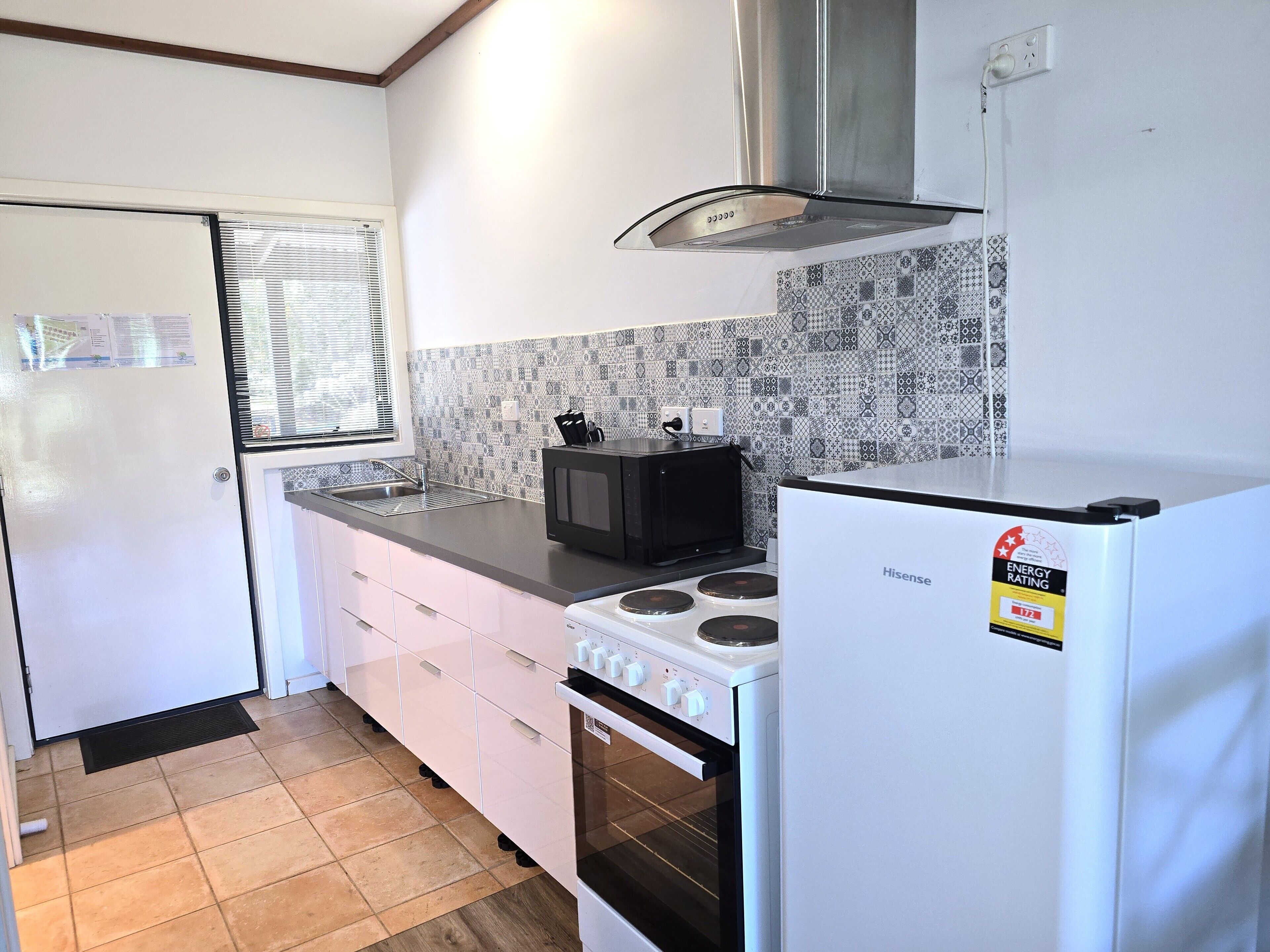 A kitchen with a stove, microwave, and refrigerator.