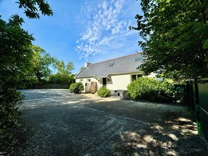 Une maison avec une allée en gravier, une porte d’entrée et un garage.