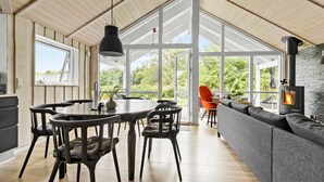 A spacious room with a large dining table and chairs, a sofa, and a fireplace. - 3 bedroom beautiful home in Glesborg (Glesborg)