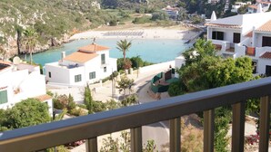 A coastal view with a beach, white buildings, and a clear sky. - Modern apartment with a fantastic view over the bay (Cala en Porter)