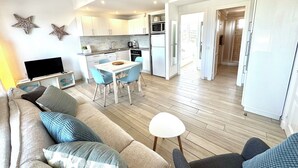 A modern apartment with a living room, kitchen, and dining area. - Modern apartment with a fantastic view over the bay (Cala en Porter)