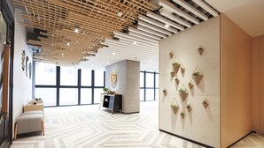 Un interior moderno con suelo de patrón geométrico, techo de listones de madera y pared decorada con plantas colgantes.