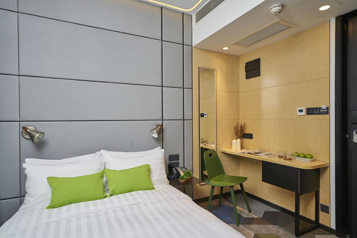 Une chambre d’hôtel moderne équipée d’un lit, d’un bureau et d’une chaise.