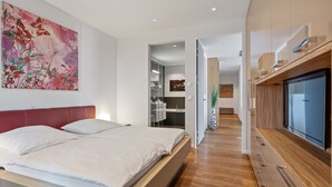 A modern bedroom with a large bed, a red headboard, and a large abstract painting. - Marco Polo Tower, Hafencity, pure luxury, air conditioning, harbor view, (Hamburg)
