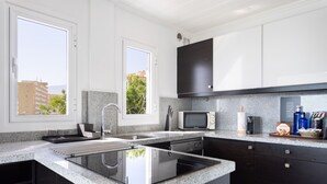 A modern kitchen with a built-in stove, a microwave, and a sink. - Over the Ocean with pool (Candelaria)