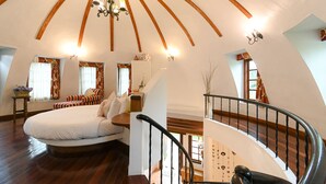 A spacious bedroom with a large bed, wooden ceiling beams, and a staircase. - Swiss Valley Hip Resort (Suan Phueng)