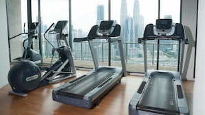A gym with treadmills and elliptical machines, large windows with a cityscape view. - Apartment at Setia Sky Residences (Kuala Lumpur)