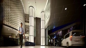 A modern hotel lobby with a curved floor, large cylindrical columns, and a patterned wall. - Apartment at Setia Sky Residences (Kuala Lumpur)