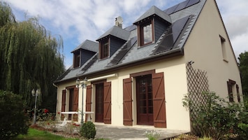 La façade de la maison avec la terrasse plein sud donnant sur le jardin