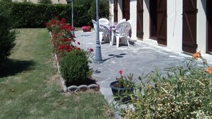 A house with a patio, outdoor furniture, and a garden.