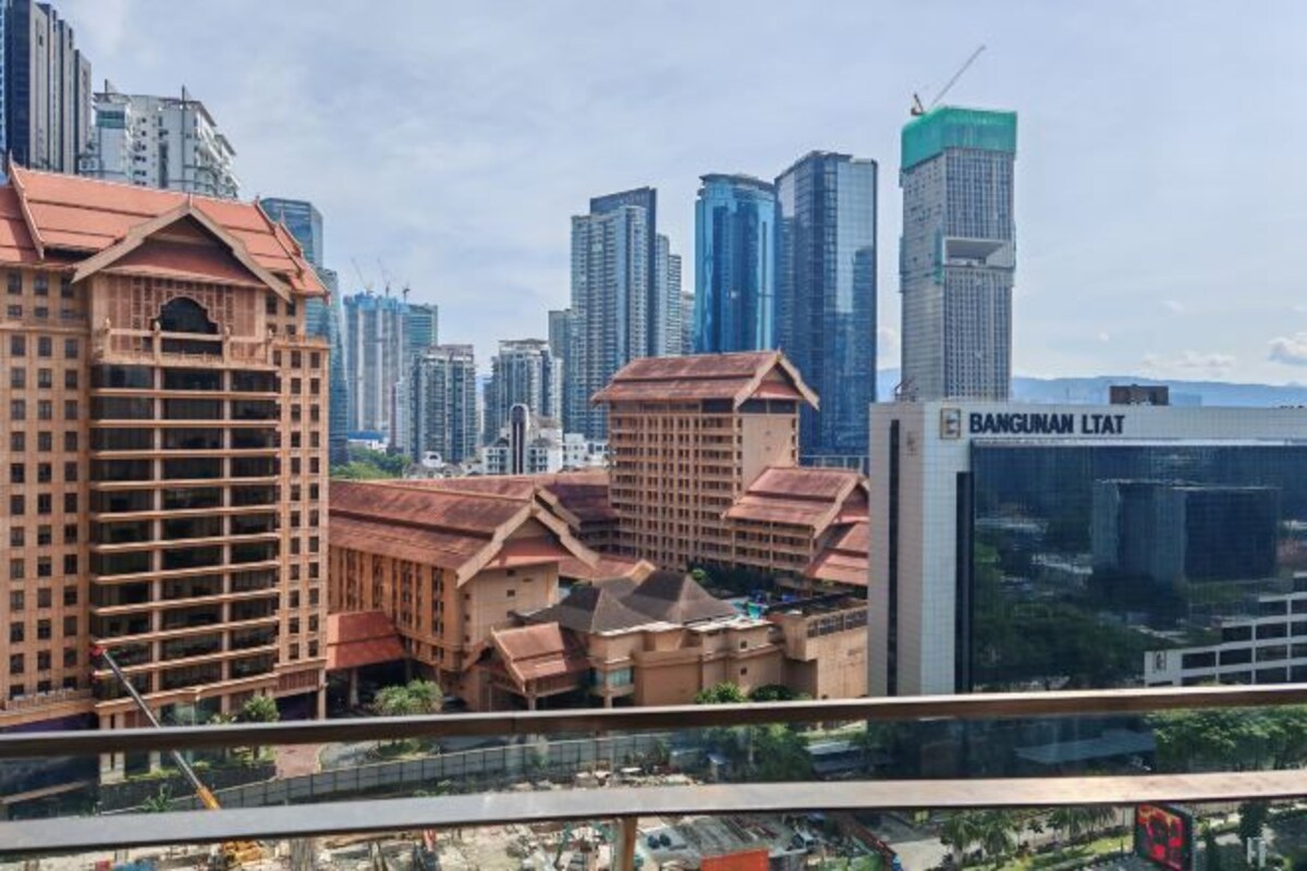 A cityscape with modern high-rise buildings and a traditional building with a red roof.