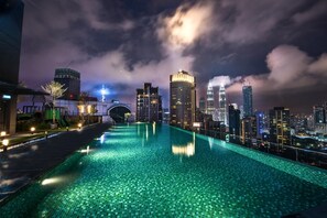 A nighttime swimming pool with city skyline views, including a prominent bridge and skyscrapers. - Dorsett Residences Bukit Bintang - Emy Room (Kuala Lumpur)