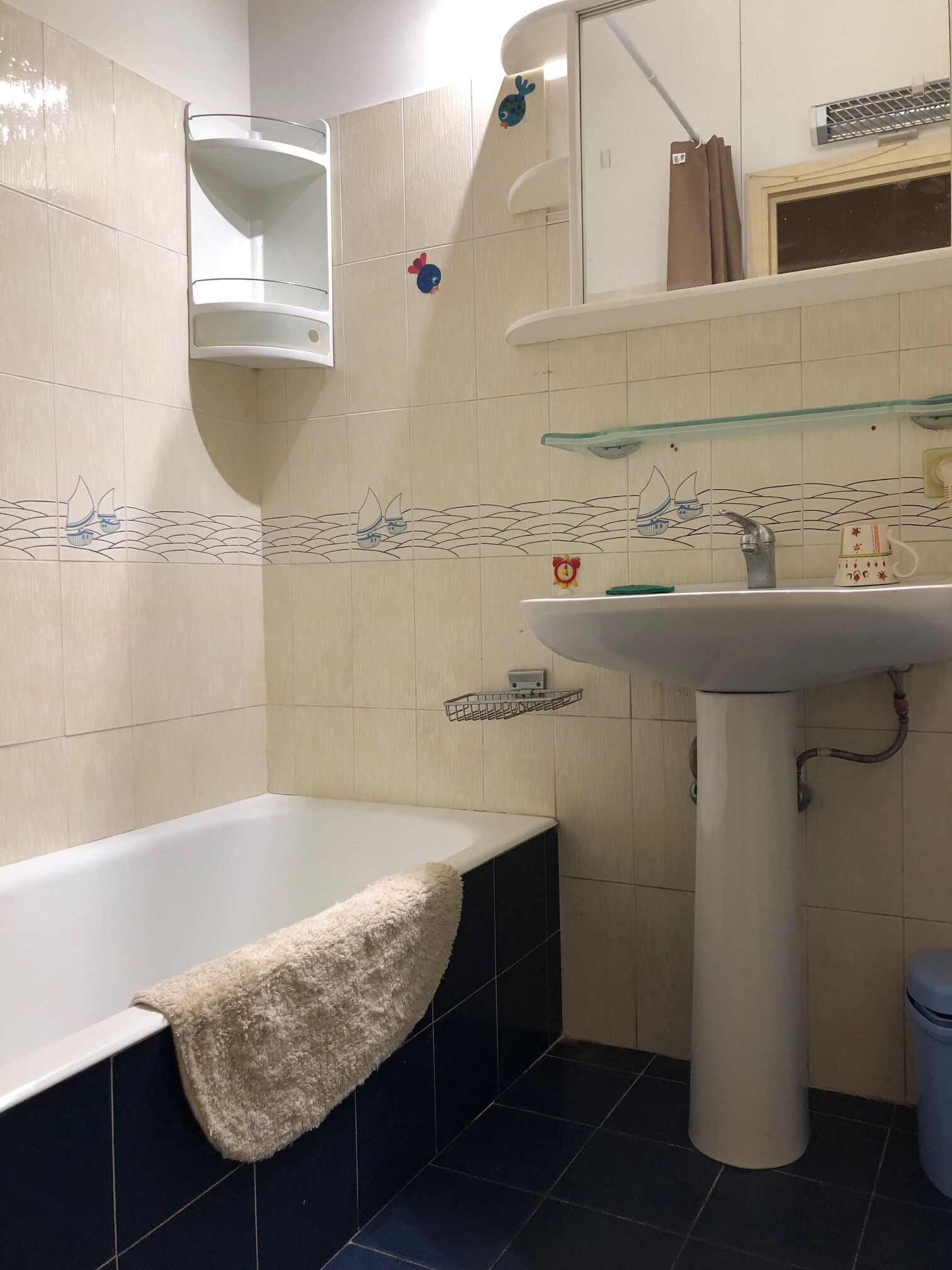 A bathroom with a bathtub, a sink, and a mirror.