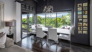 A modern dining area with a large table, white chairs, and a chandelier. - Luxury Waterfront Penthouse -Downtown Kelowna!  (Kelowna)