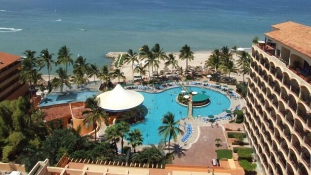 A resort with a large pool, palm trees, and a view of the ocean. - Oceanfront 2 Bedroom, Spectacular Ocean Views, 59.00/nt May-Oct, monthly rental (Puerto Vallarta)