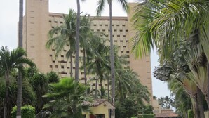 A building with a modern design, surrounded by palm trees and a small kiosk. - Oceanfront 2 Bedroom, Spectacular Ocean Views, 59.00/nt May-Oct, monthly rental (Puerto Vallarta)