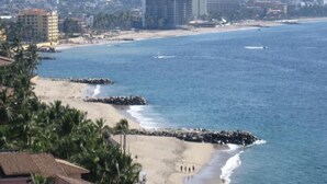 A coastal cityscape with a beach, buildings, and a rocky shoreline. - Oceanfront 2 Bedroom, Spectacular Ocean Views, 59.00/nt May-Oct, monthly rental (Puerto Vallarta)