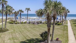 A beach view with palm trees, a pathway, and a pool area. - Sandpiper 109 - Ground floor with all the upgrades! (St. Augustine)