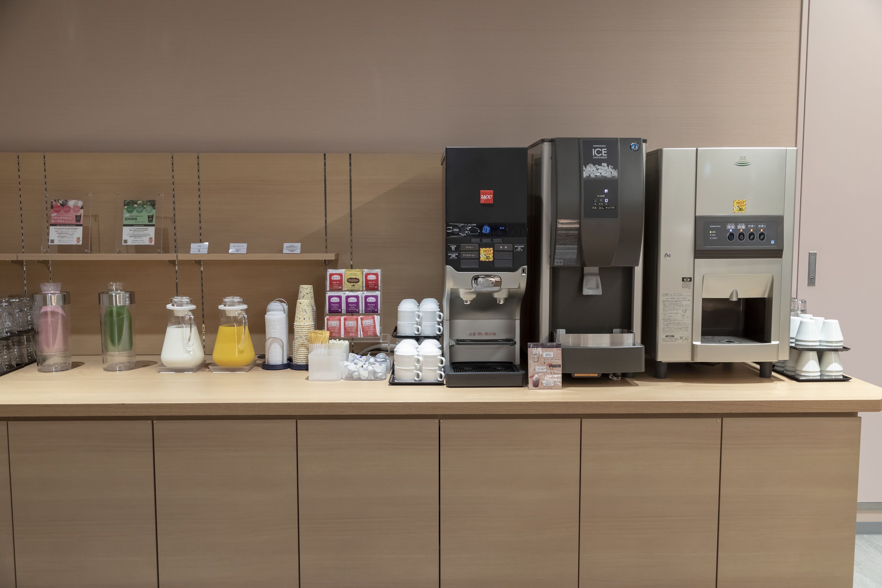 A coffee station with multiple coffee machines and dispensers, and various beverage containers.