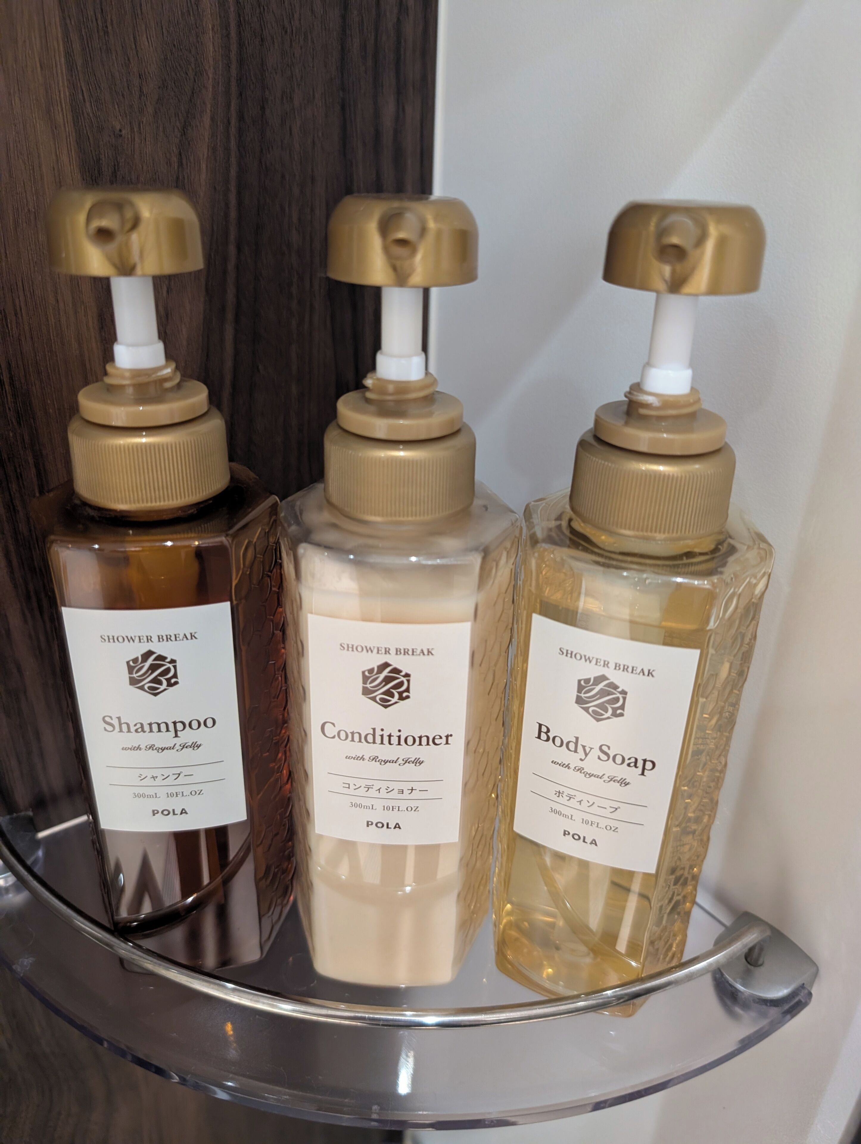 Three bottles of shower products on a shelf.