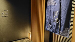A traditional Japanese room with a sliding door, a wooden panel wall, and a sign indicating the men's section. - Dormy Inn Korakuen Hot Springs (Tokyo)