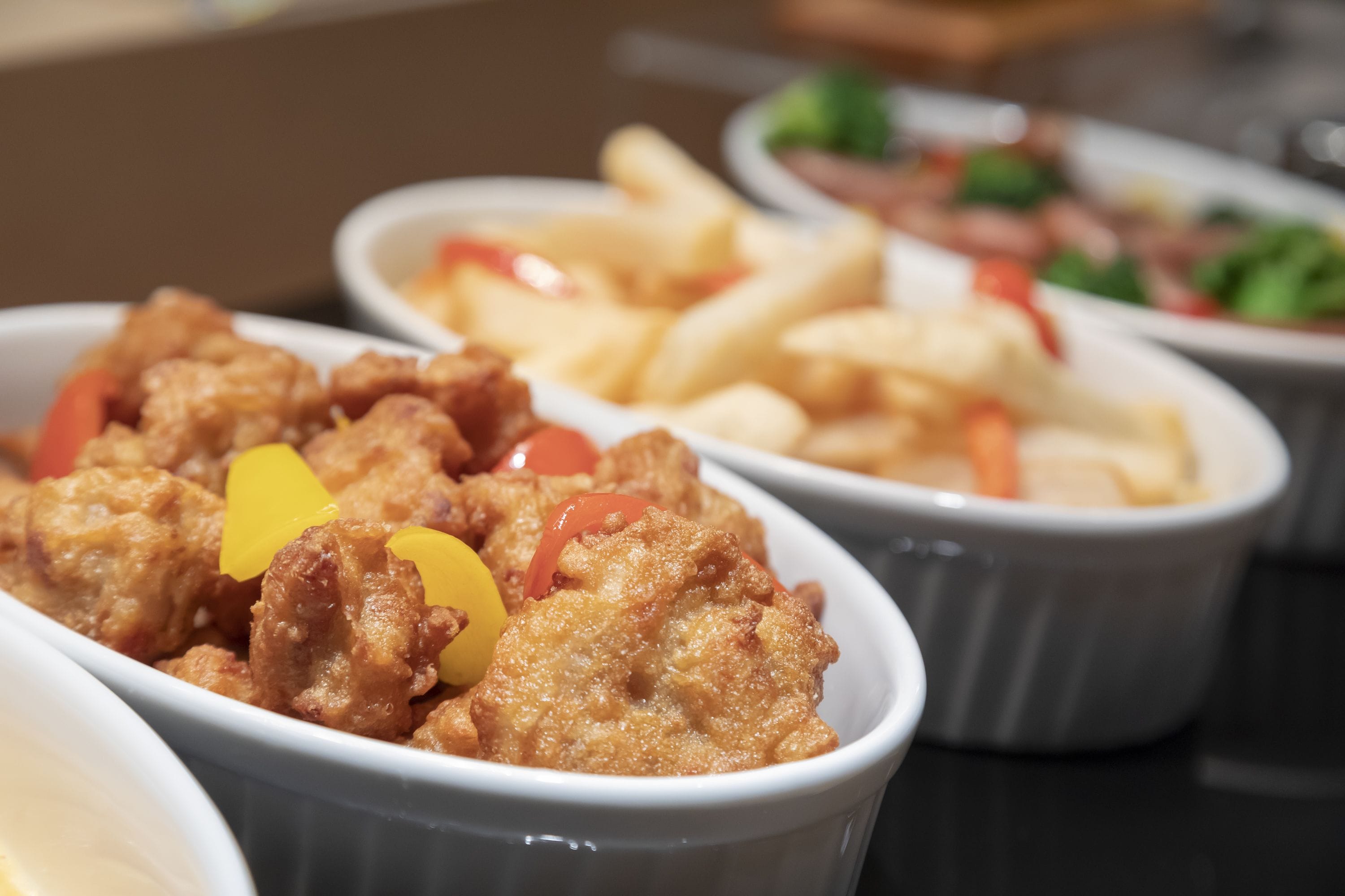 A close-up of a dish with fried chicken and bell peppers.