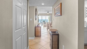 A hallway with a white door, a wooden cabinet, and a wicker basket.