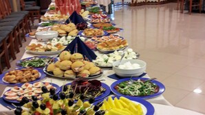 Ein Buffet mit verschiedenen Speisen und einer Reihe von Stühlen.