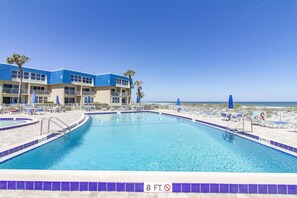 Relax by the pool surrounded by lounge chairs and umbrellas.