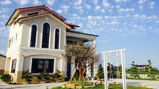 A two-story building with a white facade and a red-tiled roof. - Sweetlight B&B (Jiaoxi)