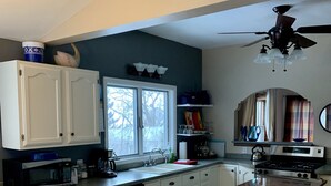 A kitchen with white cabinets, a microwave, a sink, and a stove.
