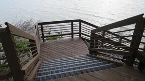 Een houten trap die naar een steiger over het water leidt.