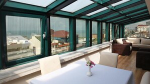A modern interior with a glass ceiling, a white table with a vase, and a sofa set. - Konak Park Hotel (Akçaabat)