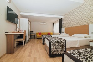 A hotel room with two beds, a desk, a television, and a sofa. - Konak Park Hotel (Akçaabat)