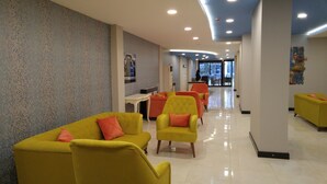 A hotel lobby with yellow sofas, a reception desk, and a large window. - Konak Park Hotel (Akçaabat)
