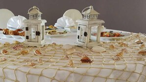 A table set with white tablecloths, white chairs, and decorative lanterns. - Baia dell'est (Montauro)
