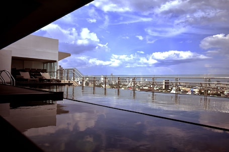 Una piscina al aire libre, sillones reclinables de piscina