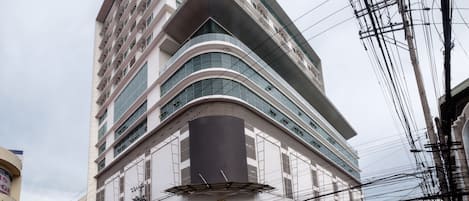 A multi-story hotel with a modern design, featuring a curved facade and large windows.
