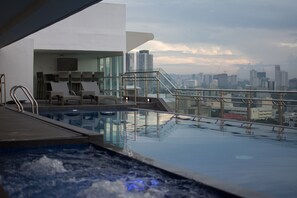 Una piscina al aire libre, sillones reclinables de piscina
