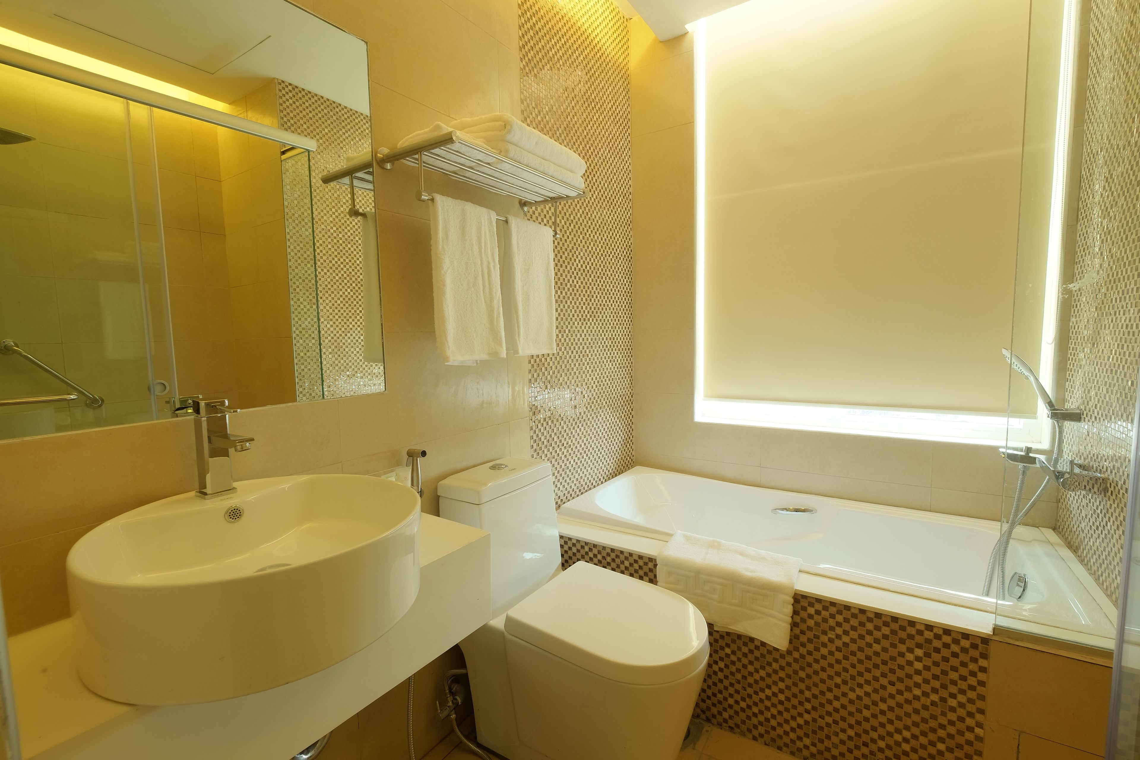 A modern bathroom with a large sink, toilet, and bathtub.