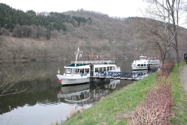 Un río tranquilo con dos barcos amarrados a un muelle.