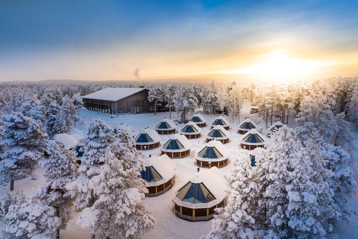 A snow-covered landscape with a large building and several dome-shaped cabins.
