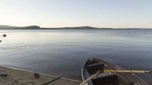 A calm lake with a small boat docked at the shore.