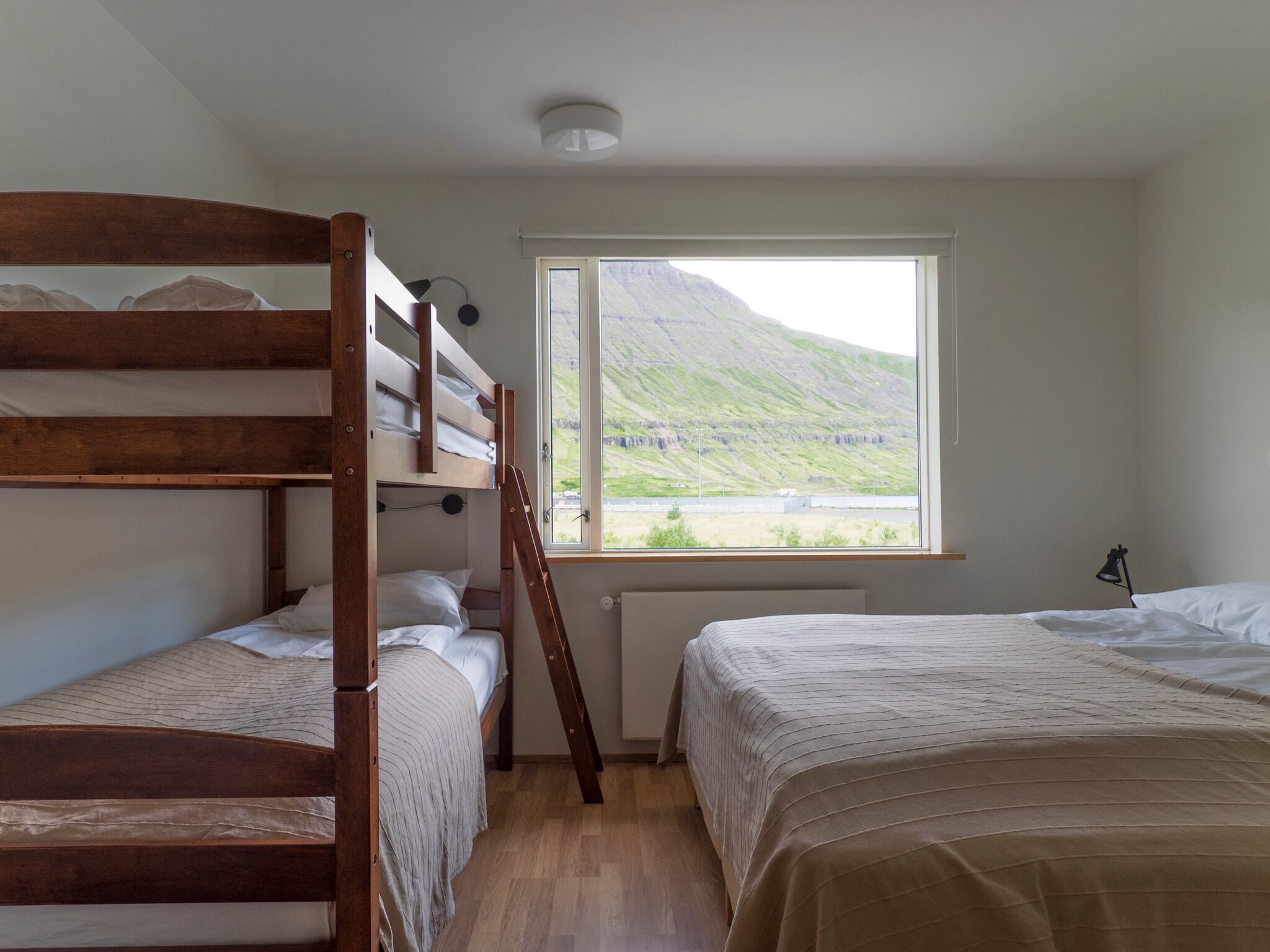 Ein Zimmer mit Etagenbetten und einem Fenster mit Bergblick.