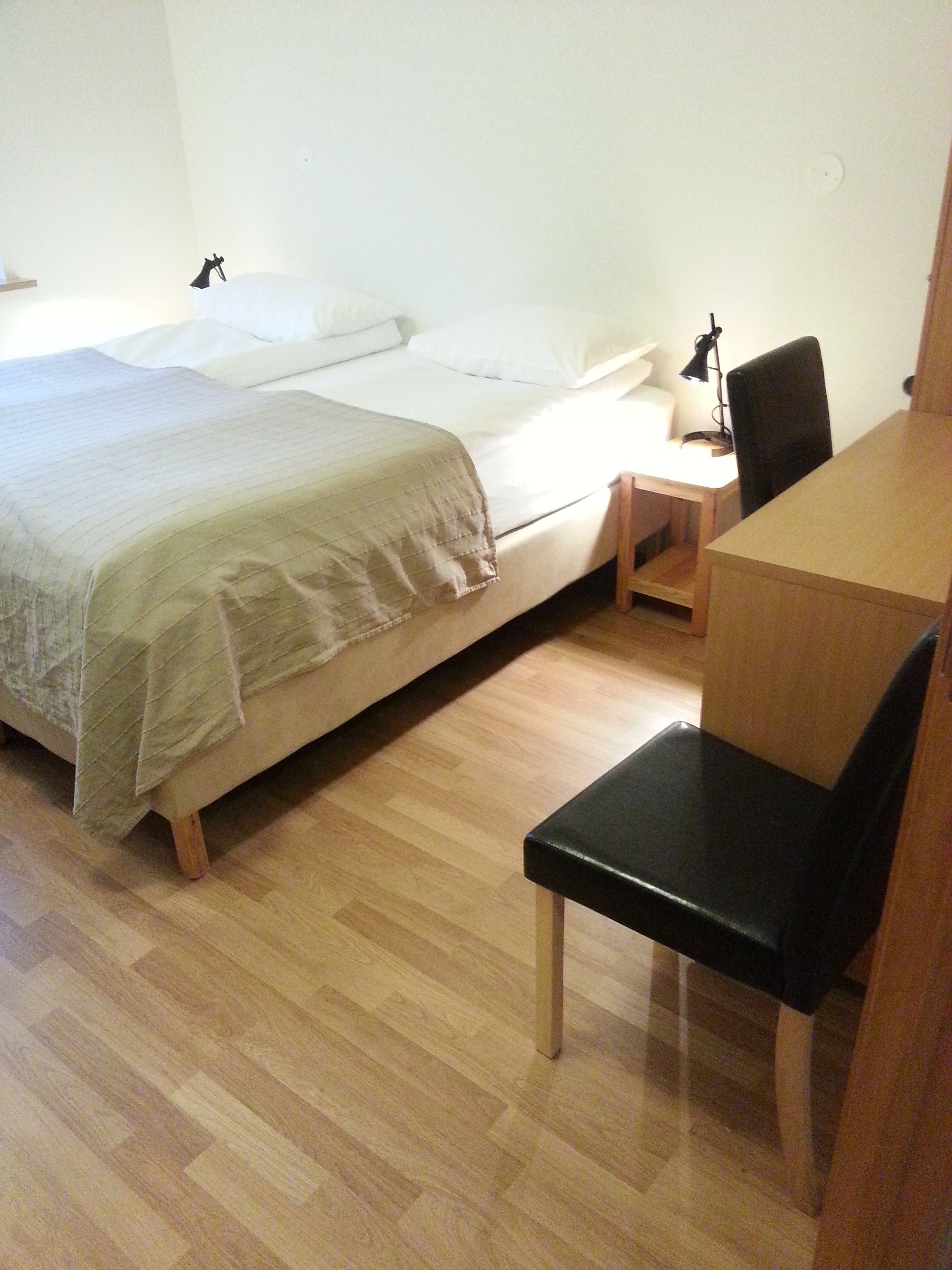 Ein Schlafzimmer mit einem Bett, einem Schreibtisch und einem Stuhl.