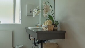 A bathroom with a sink, mirror, and a window. - Seyðisfjörður Guesthouse (Seydisfjordur)