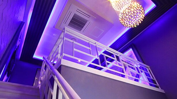 Una escalera moderna con barandilla de metal que da a un balcón.