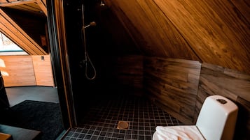 Cozy cabin room with a single toilet, shower area, and compact layout.