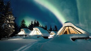 A snow-covered landscape with tents and a view of the Northern Lights. - Wilderness Hotel Nellim & Igloos (Inari)